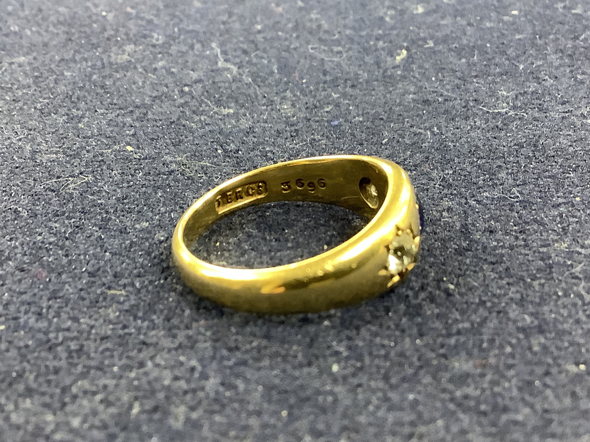 A late Victorian 18ct gold and gypsy set sapphire and diamond three stone ring, size N, gross 5.8 grams.
